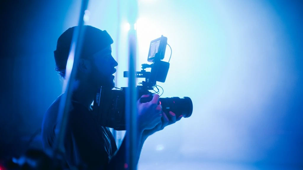 Étudiante en cinéma ajustant une optique Cooke sur un boîtier ARRI en atelier